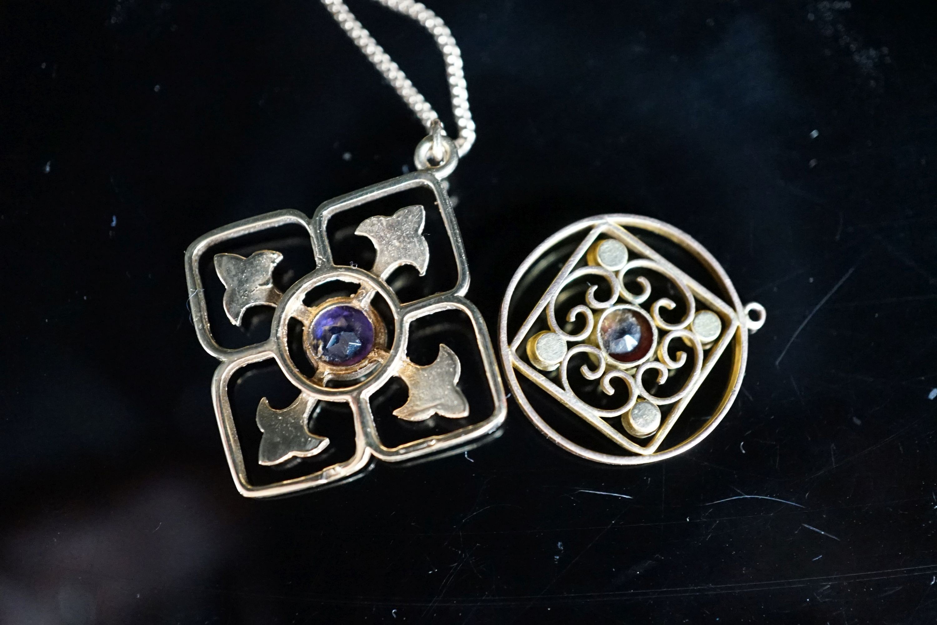 Two yellow metal and gem set pendants, including circular garnet and seed pearl set, 17mm, the largest on a 9ct gold chain, gross weight 6 grams.